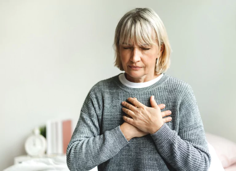 a woman holding her chest in pain
