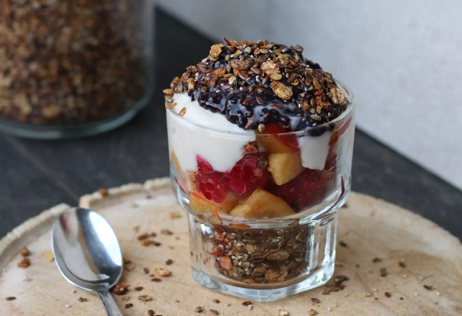 a glass of cereal, yogurt, berries and chocolate
