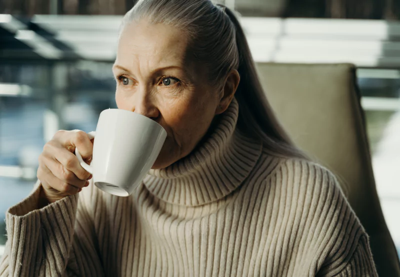 a woman drinking a cup of coffee