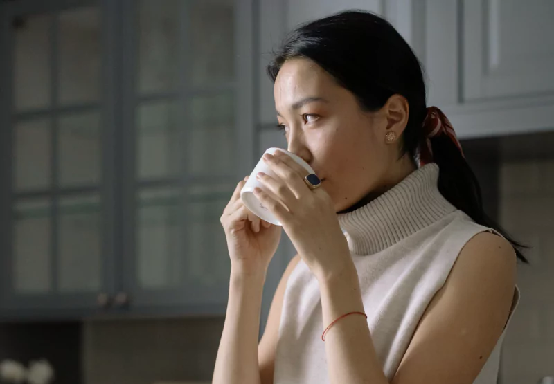 a girl drinking a cup of coff